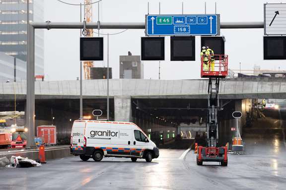 Servicebil och lyftkran framför infarten till en vägtunnel.