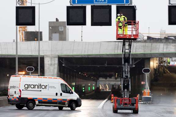 Servicebil och lyftkran framför infarten till en vägtunnel.